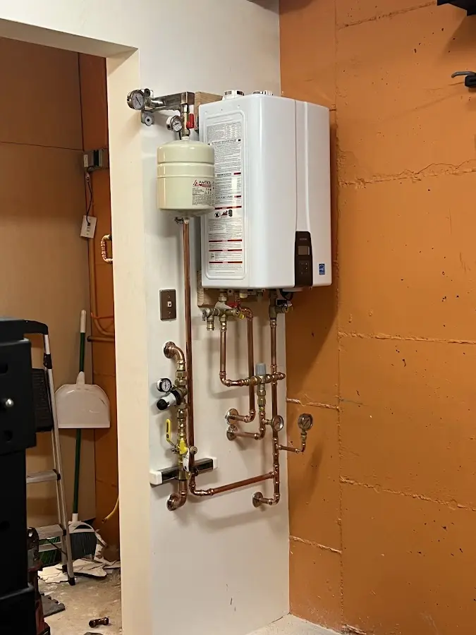 Plumbing technician inspecting water heater connections in Homedale